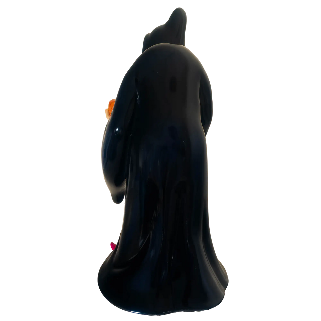 Back view dark blue witch figurine with pointed hat and pink shoes