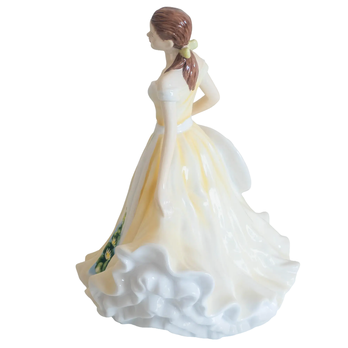 Fine bone china ballerina figurine from behind, layered white skirt with yellow accents