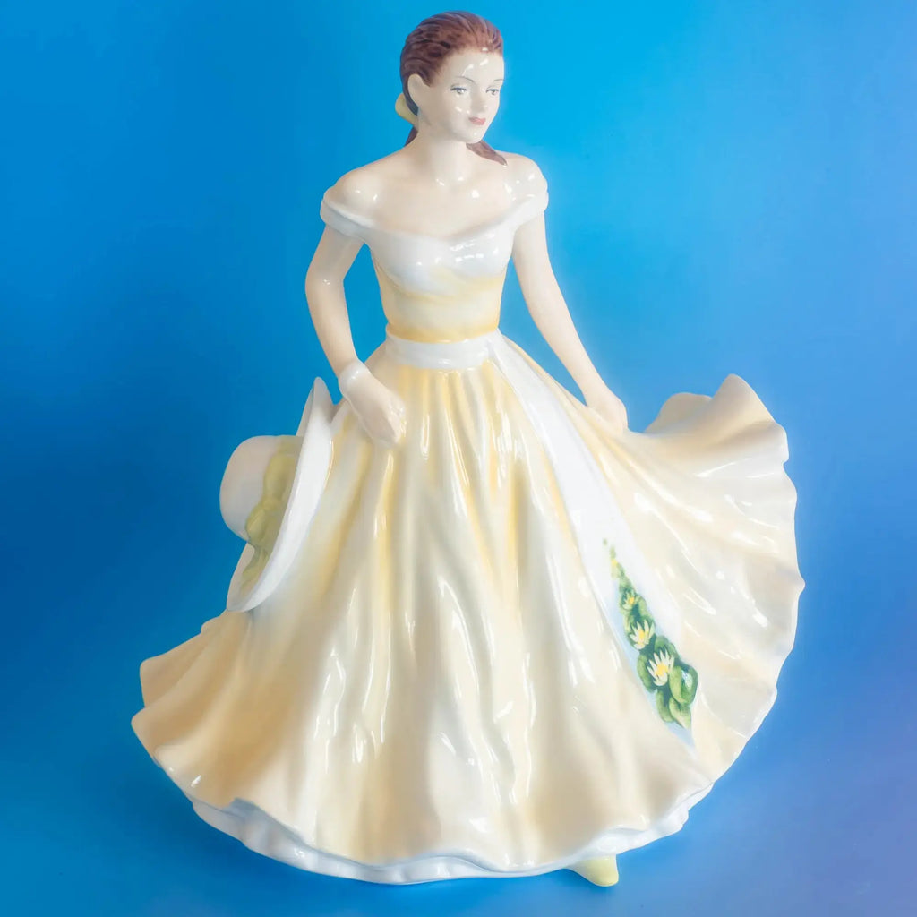 Fine bone china ballerina figurine, flowing white-and-yellow skirt with green floral detail