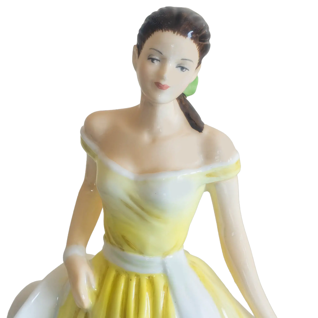 Fine bone china daffodil figurine: close view of woman with yellow bodice and pale bonnet